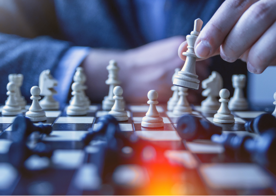 Image of a hand holding a knight on a chess board